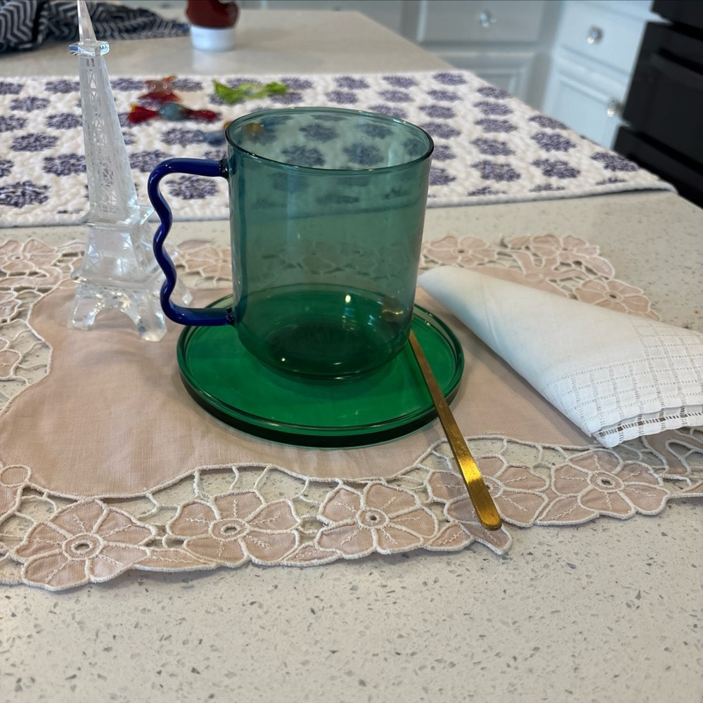 Anthropologie, glass cup and saucer with golden spoon.